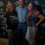 A man and two women are posing for a picture together.