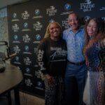 A group of people are posing for a picture in front of a blackboard.