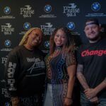 A group of people are posing for a picture in front of a wall.