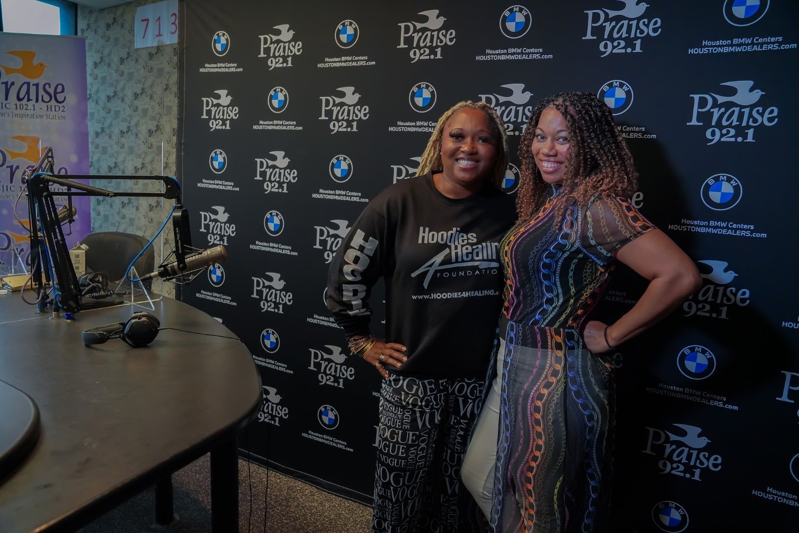 Two women are posing for a picture in a radio studio.