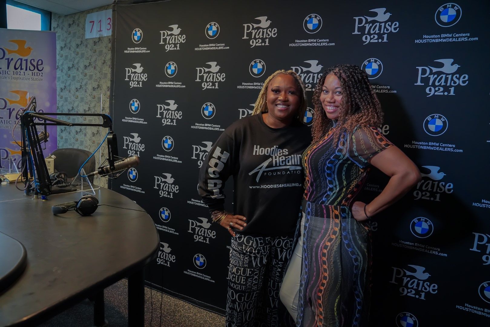 Two women are posing for a picture in a radio studio.