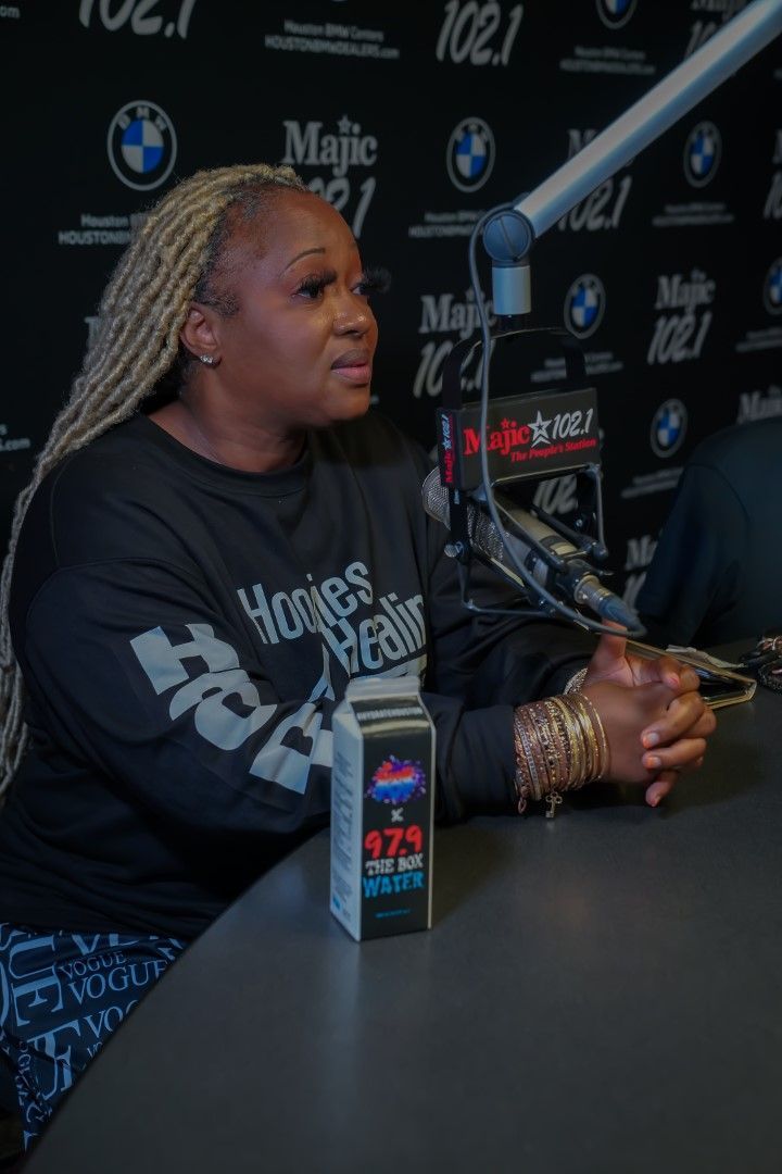A woman is sitting at a table in front of a microphone.