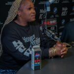 A woman is sitting at a table in front of a microphone.