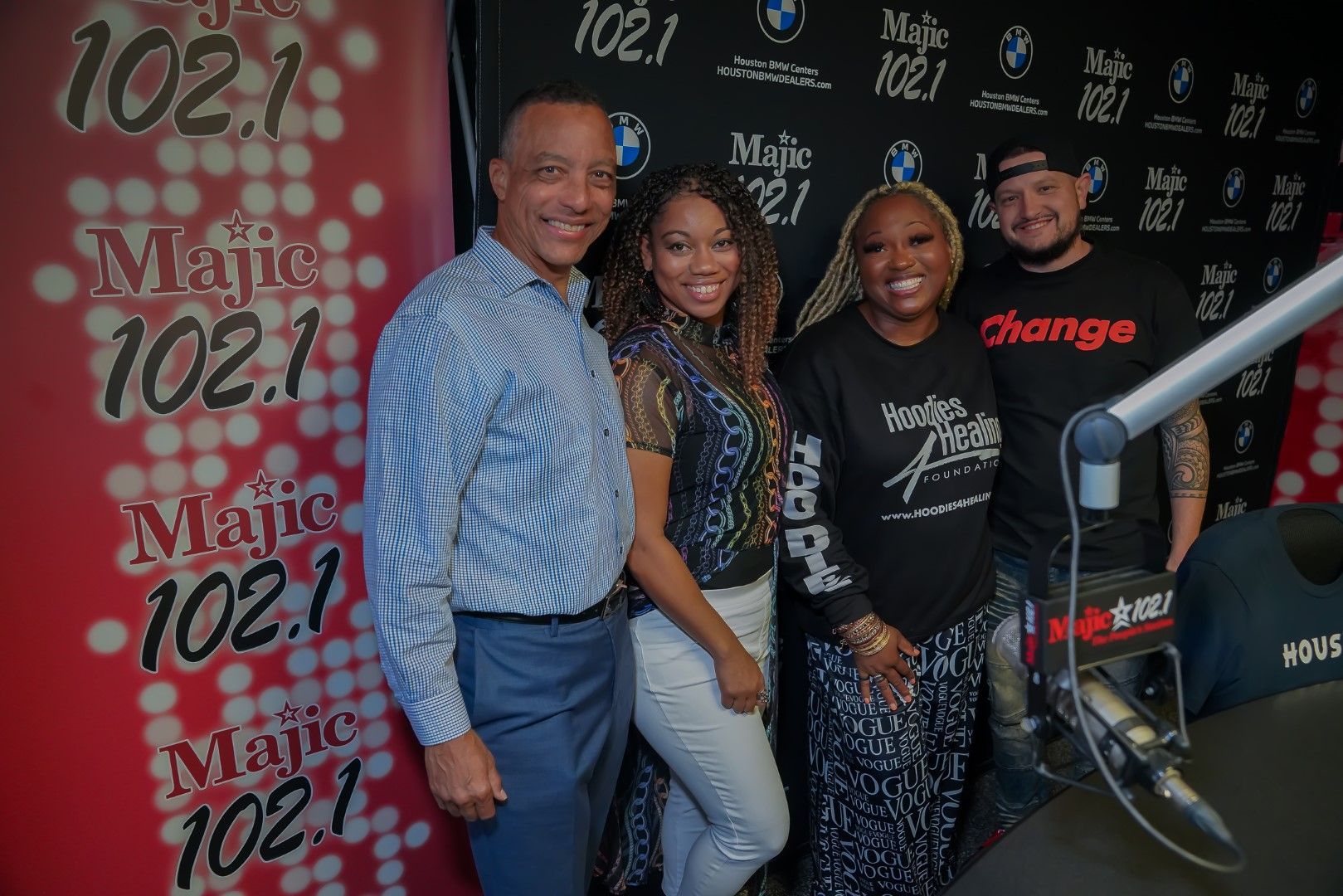 A group of people are posing for a picture in front of a microphone.