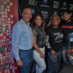 A group of people are posing for a picture in front of a wall.