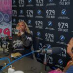 A woman is sitting at a table in front of a microphone.