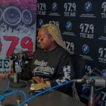 A woman is sitting in front of a microphone in a radio studio.