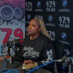 A woman is sitting at a table in front of a microphone.