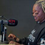 A woman is sitting in front of a microphone in a radio station.