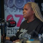 A woman is sitting in front of a microphone in a radio station.