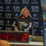 A woman is standing in front of a microphone in a radio station.