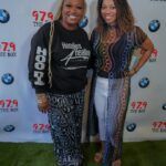 Two women are standing next to each other on a red carpet.