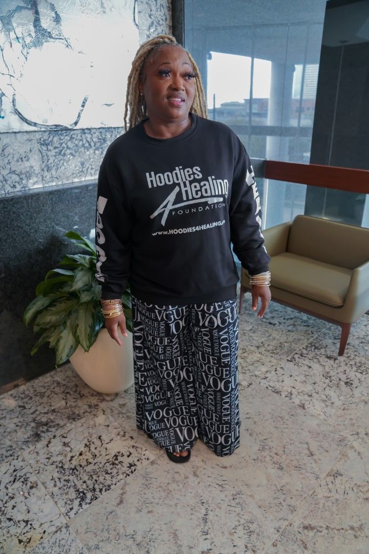 A woman wearing a black sweatshirt with the word theatre on it