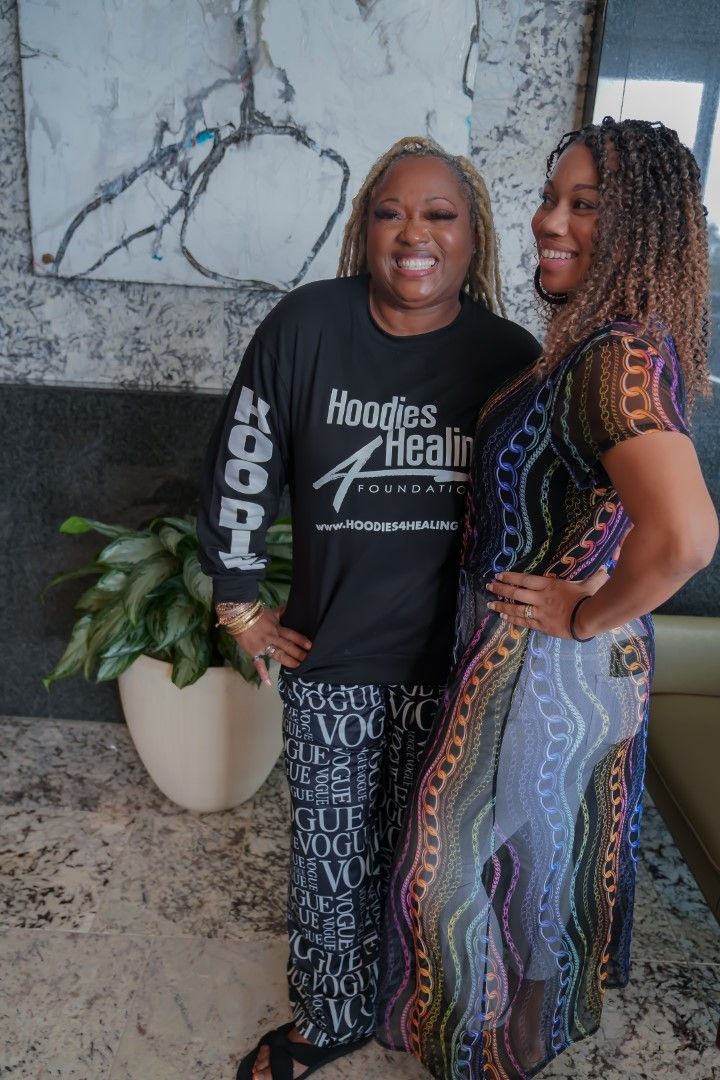 Two women are standing next to each other in a living room.