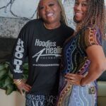 Two women are posing for a picture together in a living room.