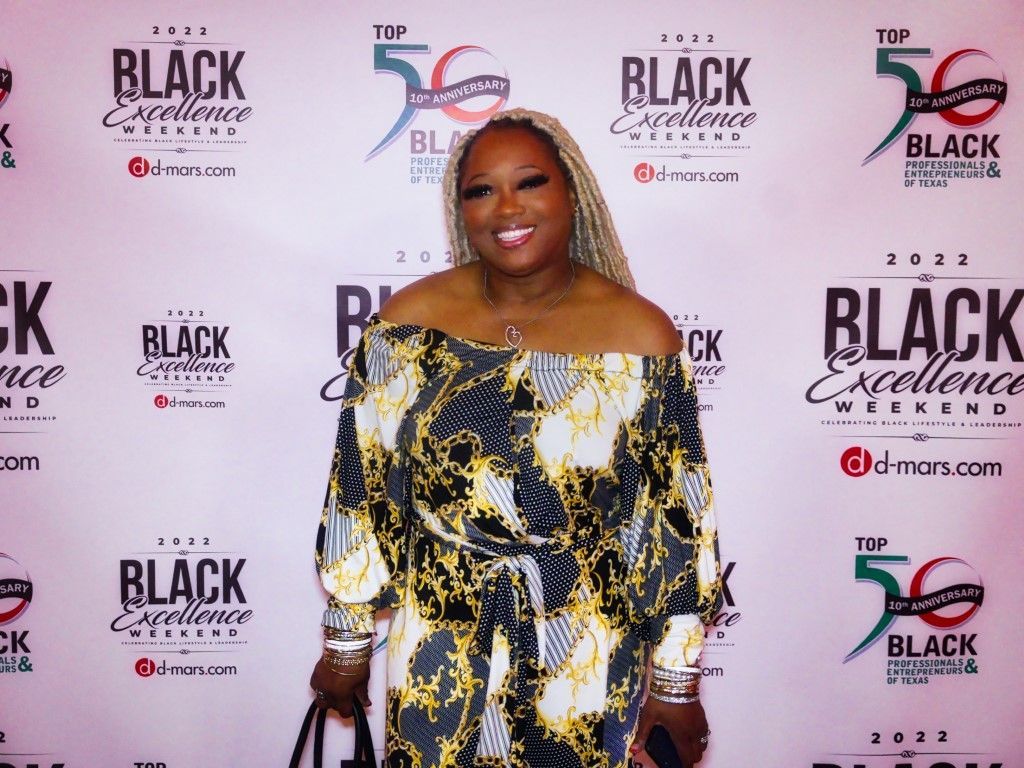 A woman in a dress is standing in front of a red carpet.