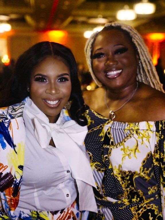 Two women are posing for a picture together and smiling for the camera.
