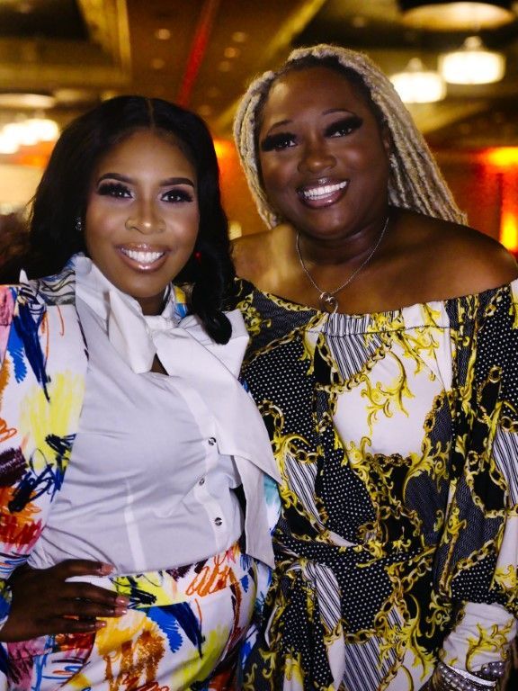 Two women are posing for a picture together and smiling.