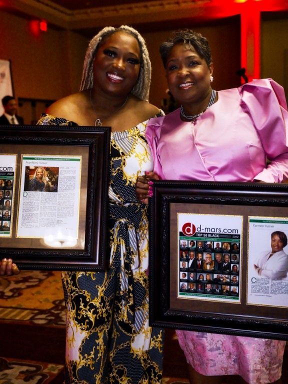 A woman in a pink dress is holding a framed picture of herself