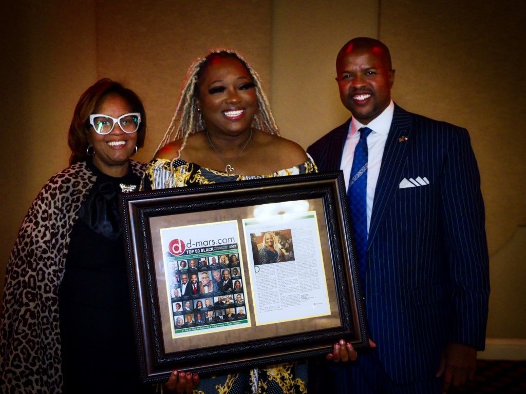 A group of people are standing next to each other holding a framed picture.