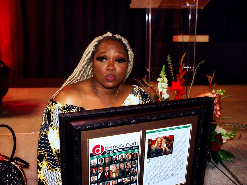 A woman is holding a framed picture in front of a podium.