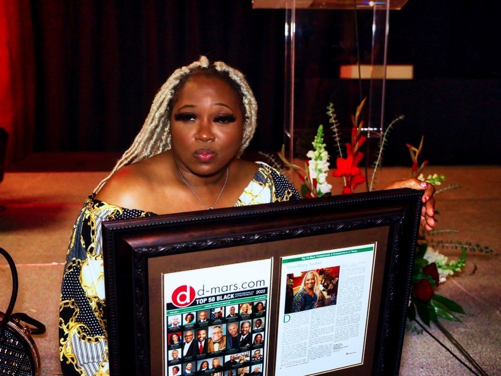 A woman is holding a framed picture of herself