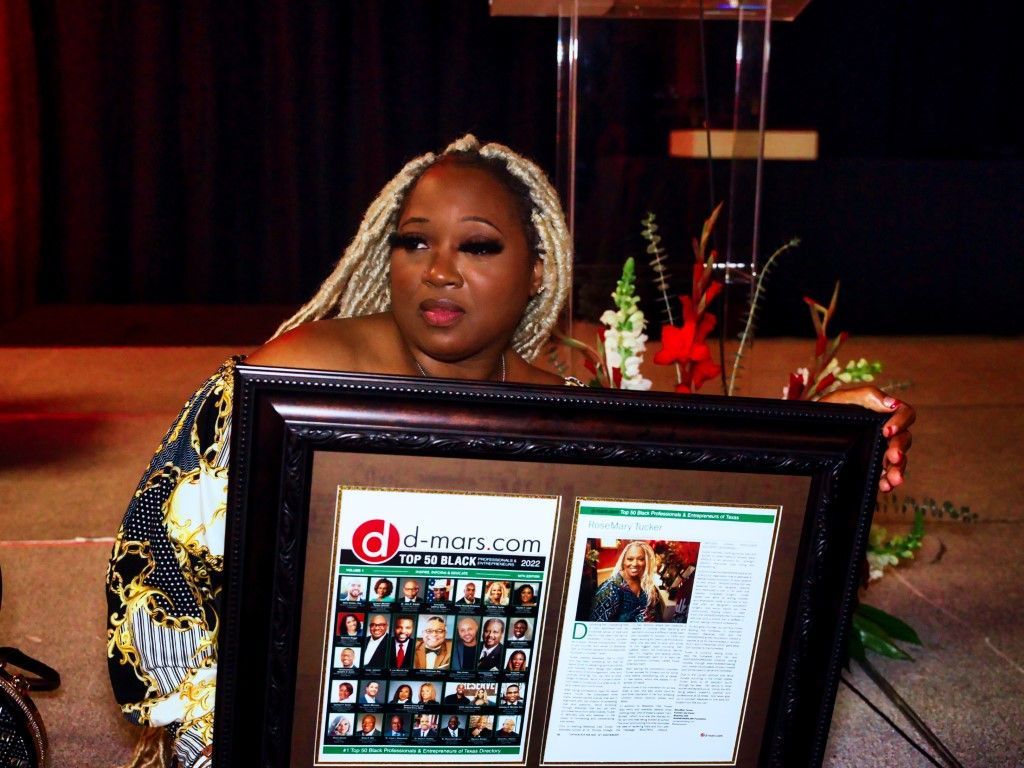 A woman is holding a framed picture that says o-man.com