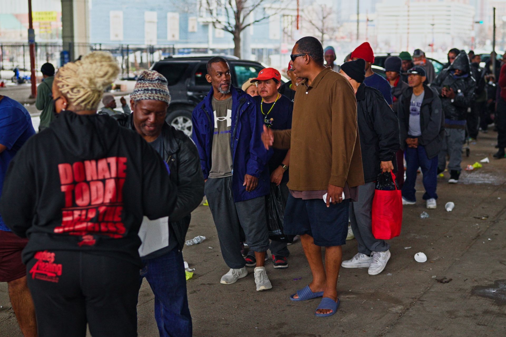 A group of people are standing in a parking lot.
