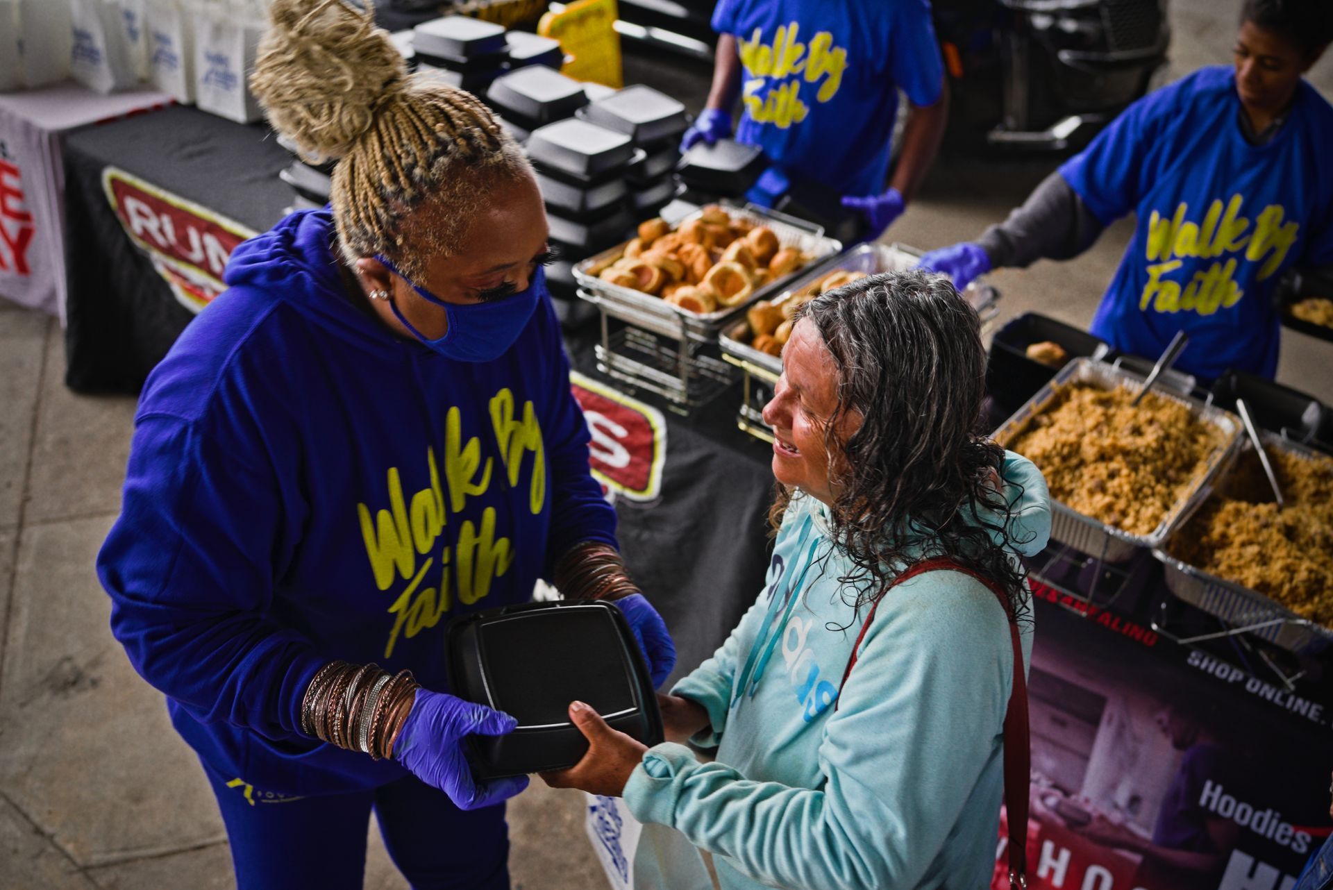 A woman is giving a wallet to another woman.