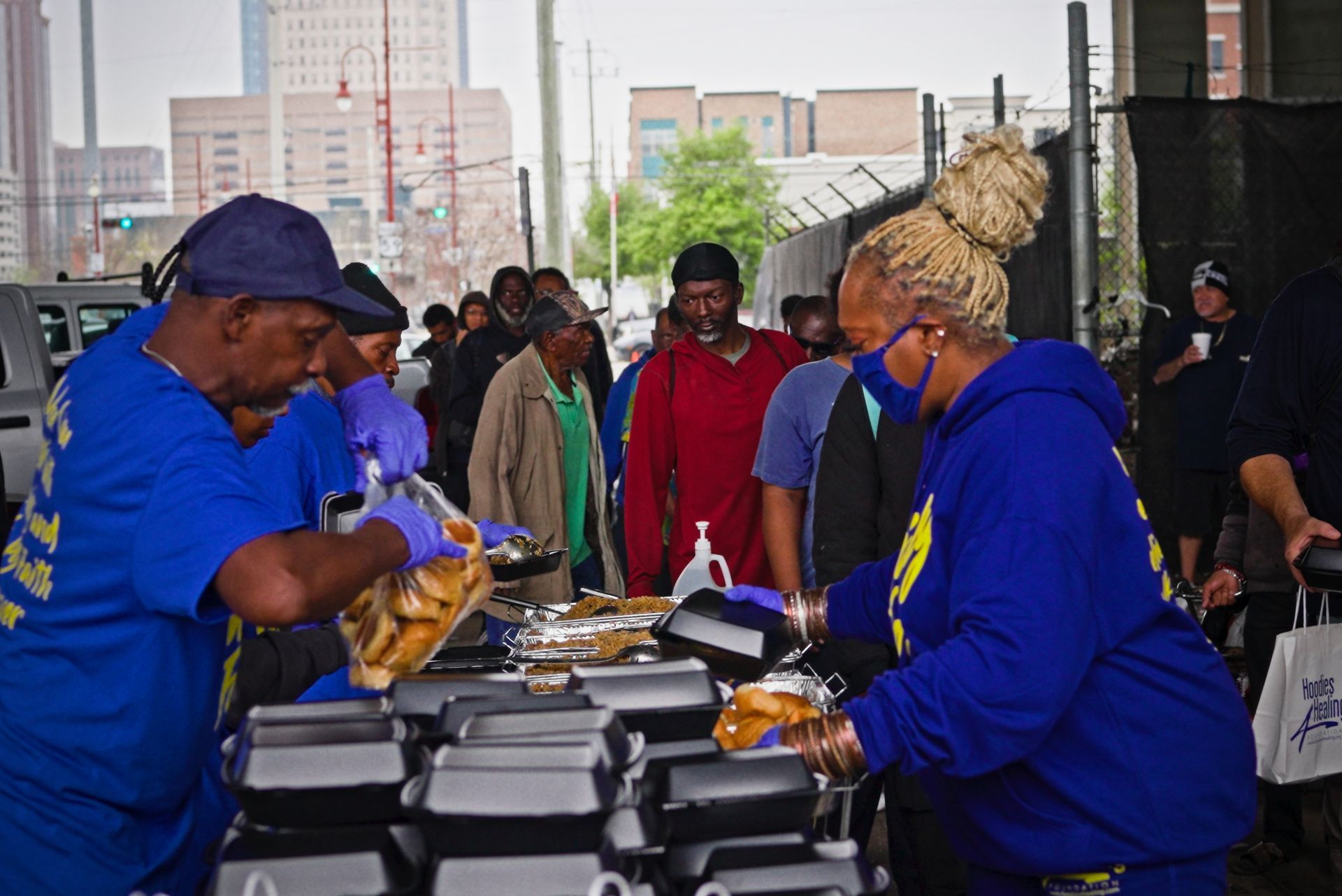 A group of people are standing around a table with boxes of food.