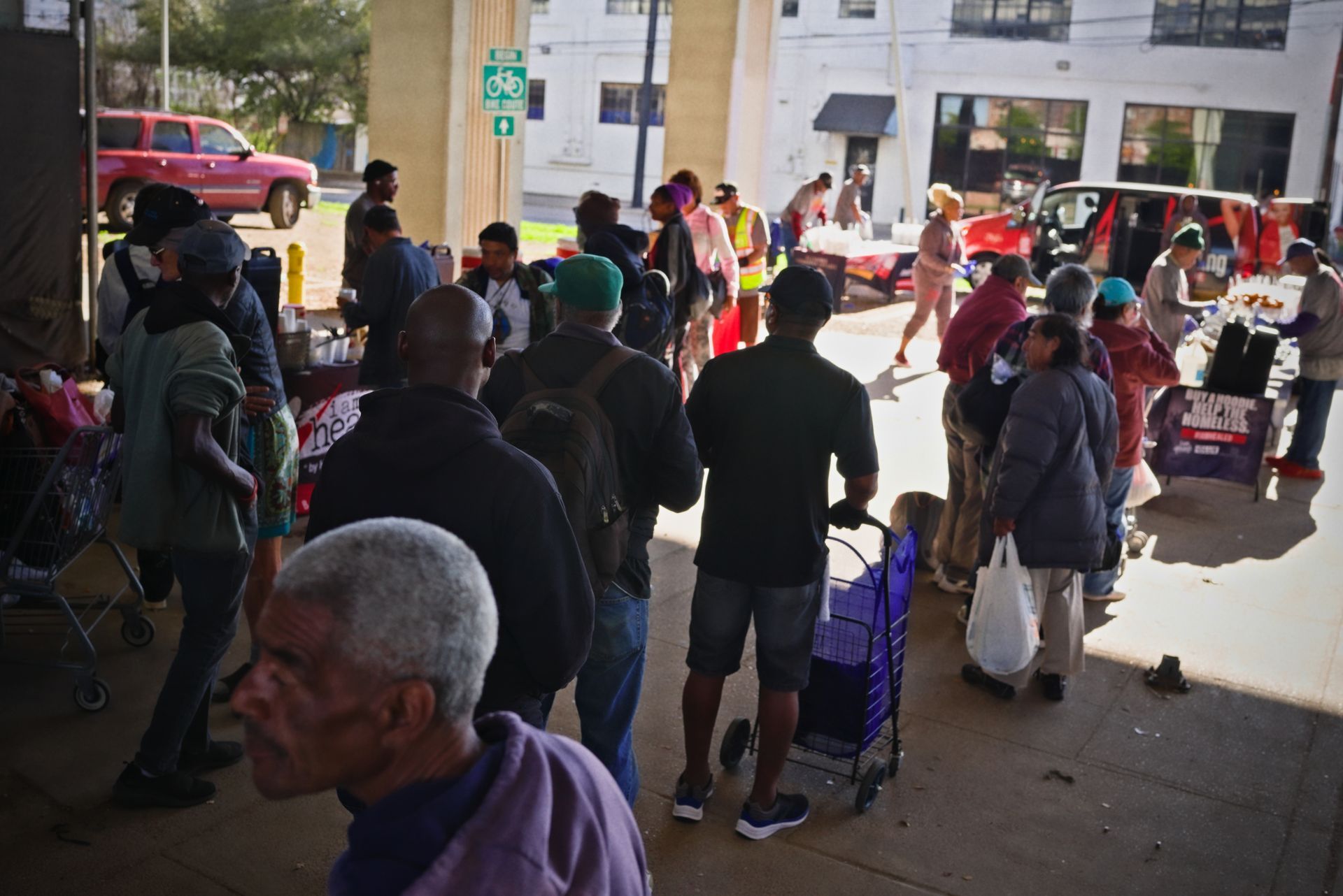 A group of people are standing in a line in front of a sign that says exit