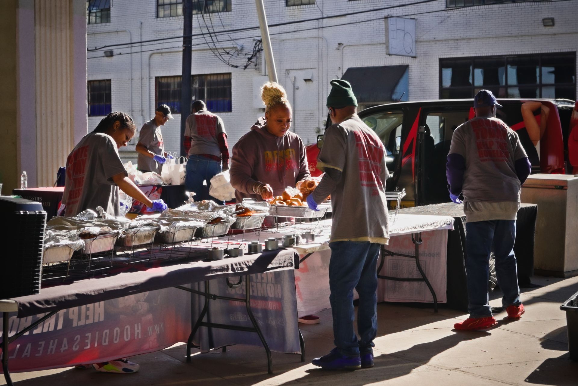 A group of people are standing around a table with a sign that says ' justice goods ' on it