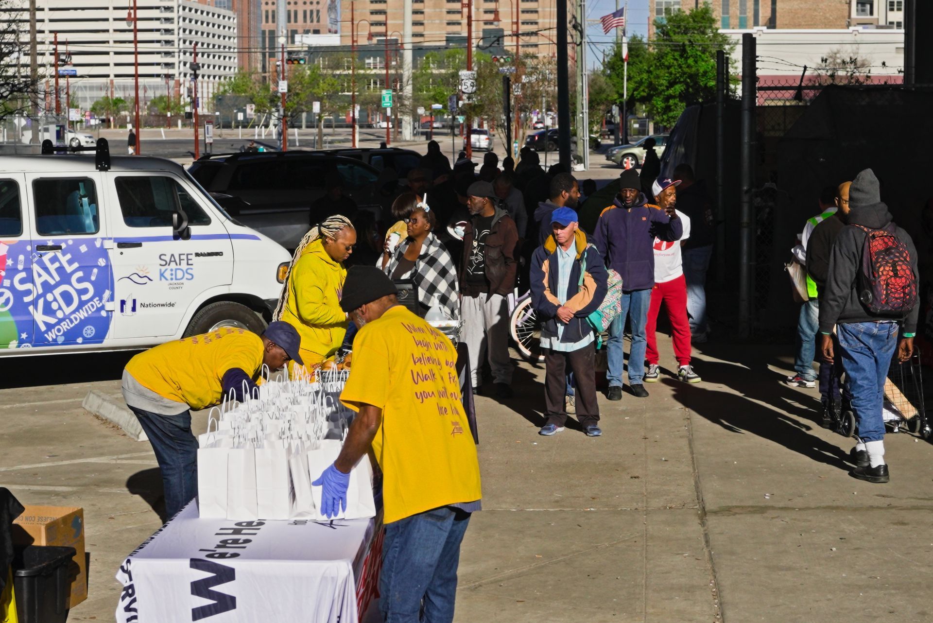 A group of people are standing in front of a van that says safe kids