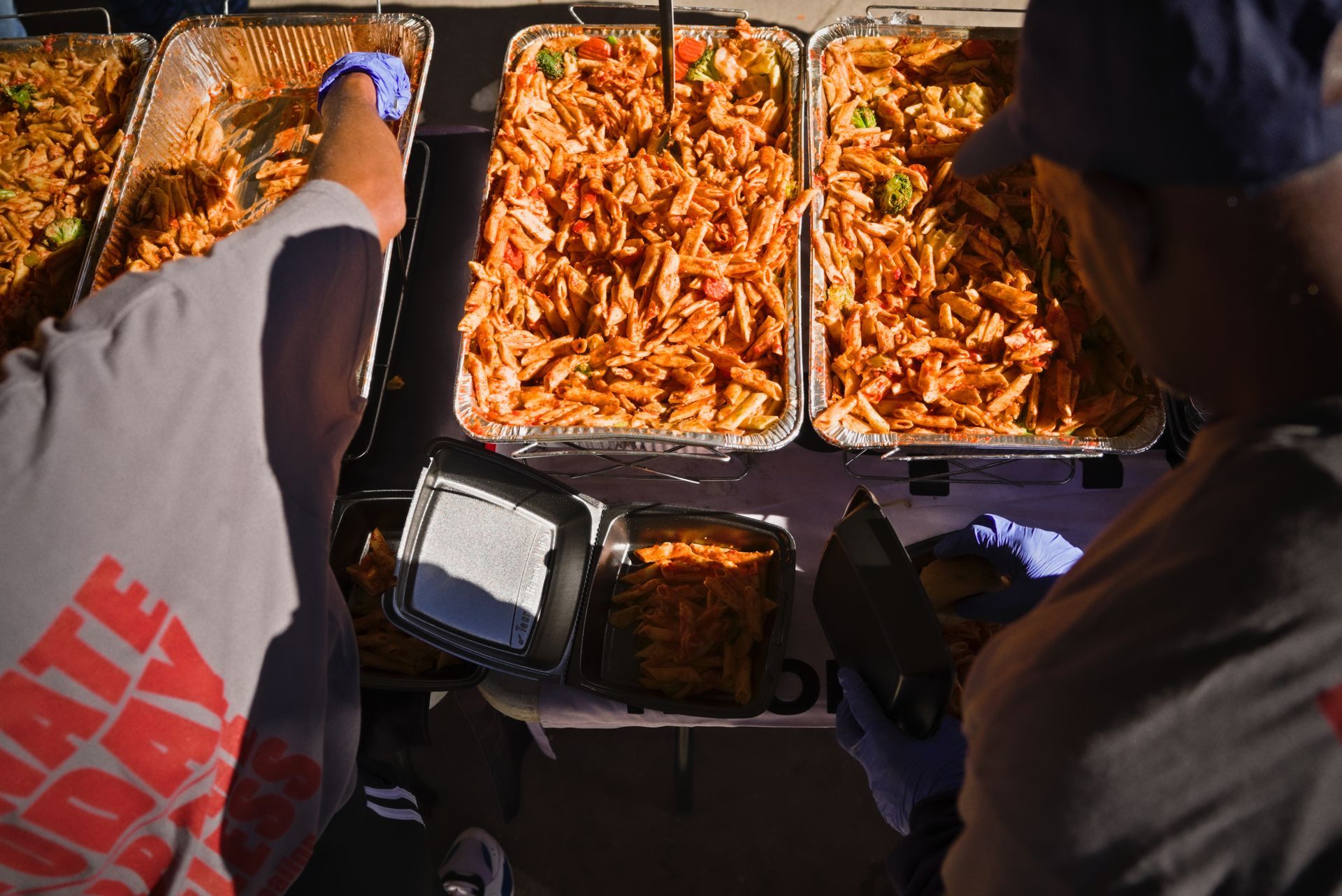 Two people are sitting at a table with trays of food.