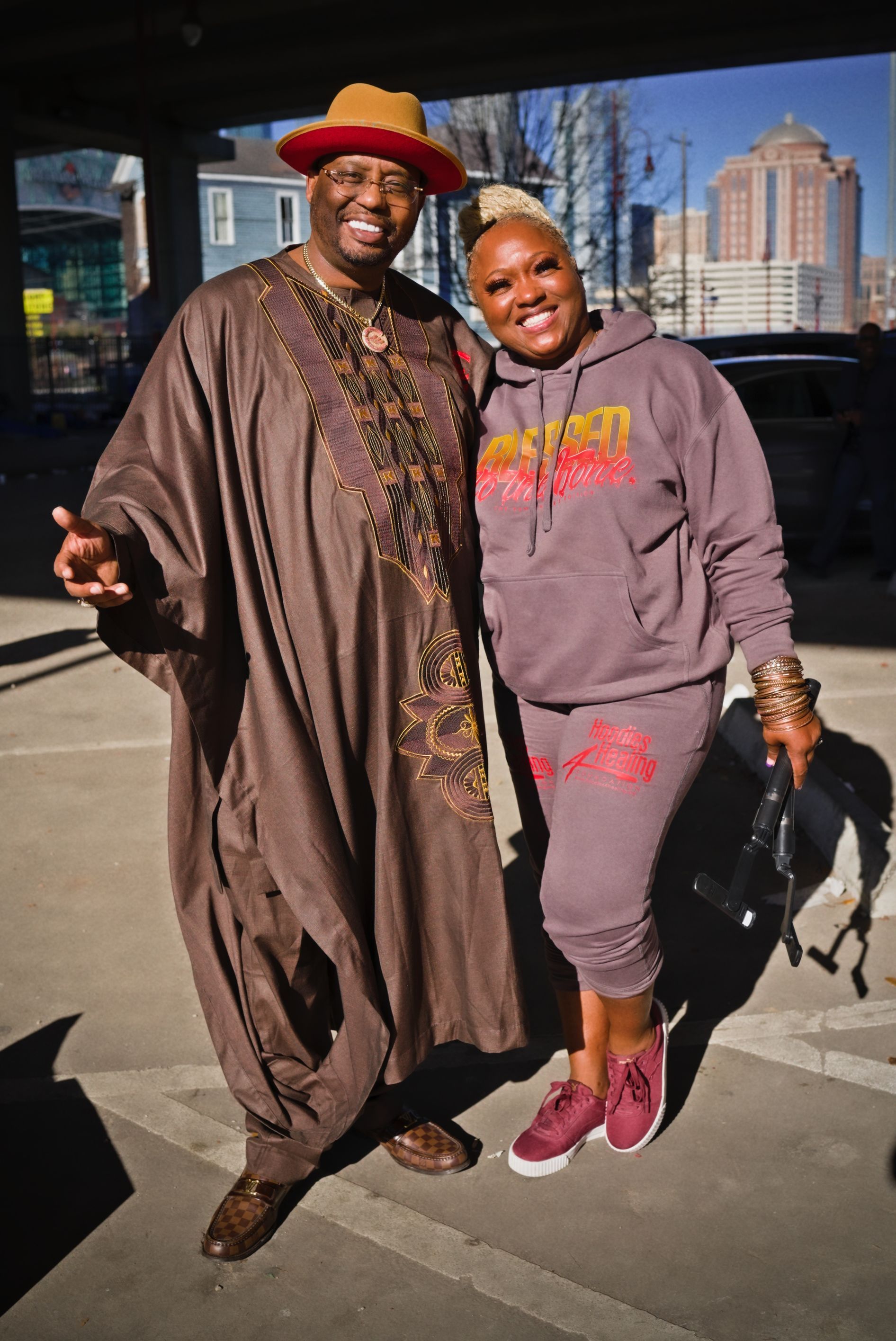 A man in a hat and a woman in a hoodie are posing for a picture.