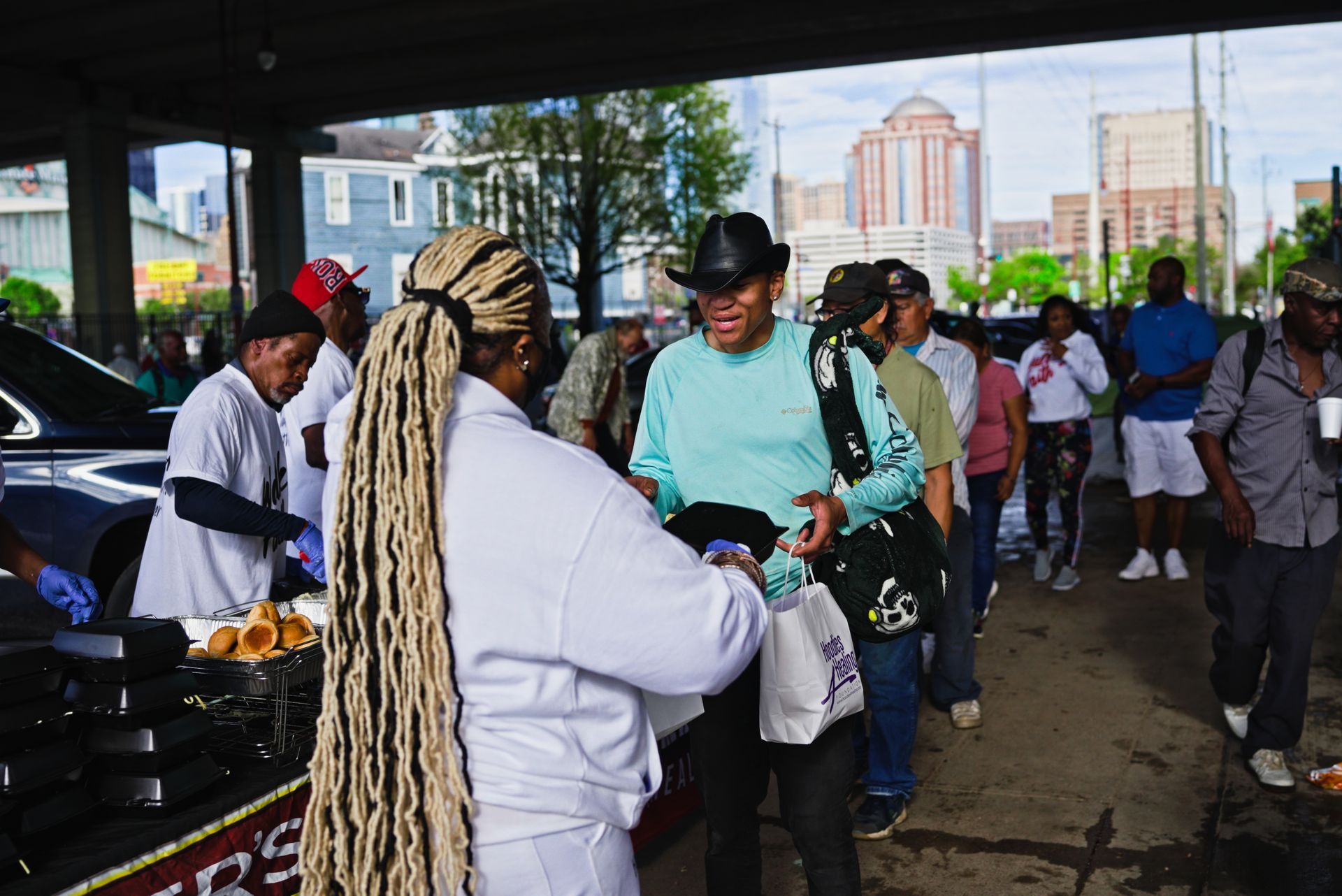 A group of people are standing around a table with a sign that says ' rs ' on it.