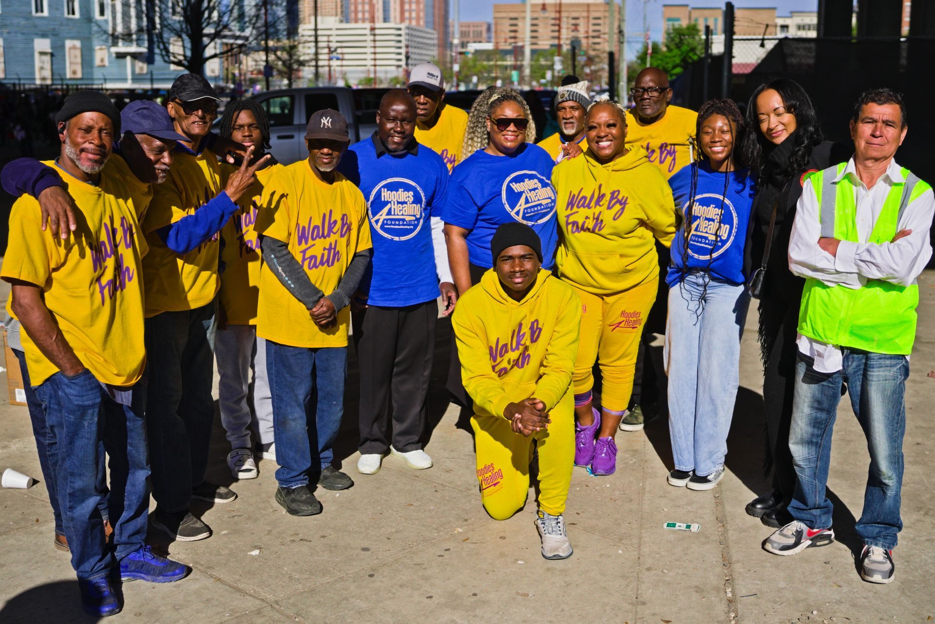 A group of people wearing yellow and blue shirts that say walk by faith