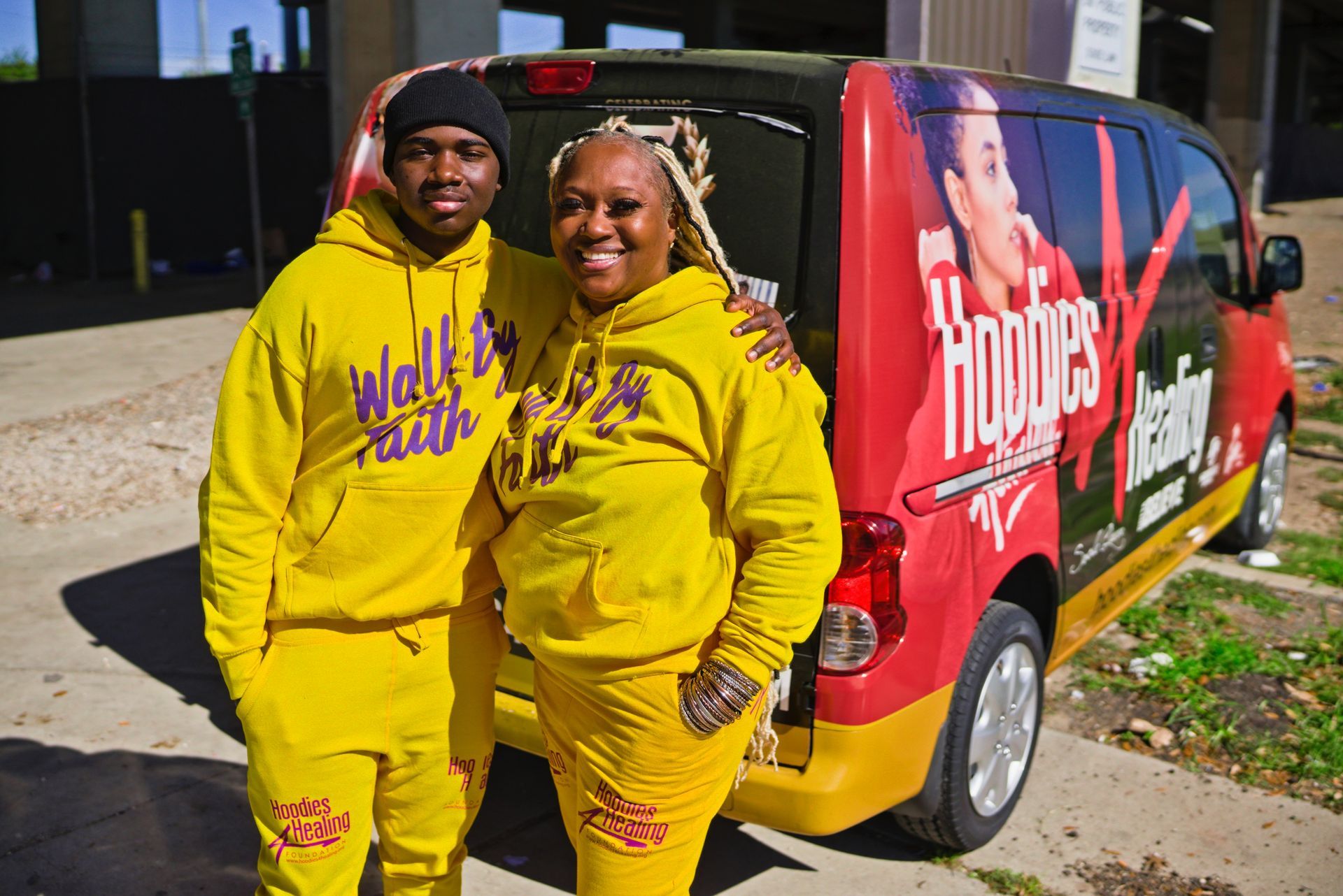 A man and a woman are standing in front of a van.