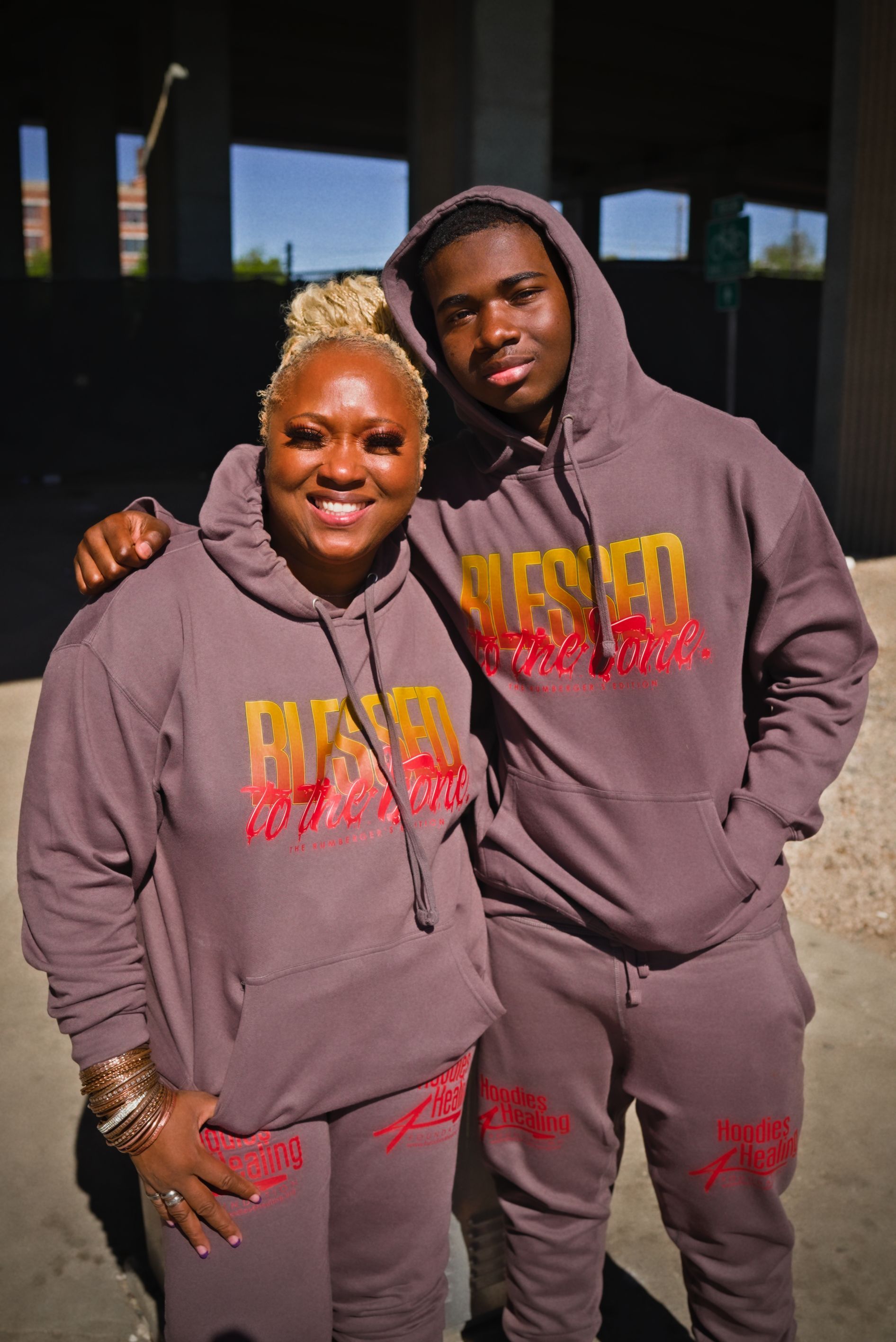 A man and a woman are standing next to each other wearing hoodies.