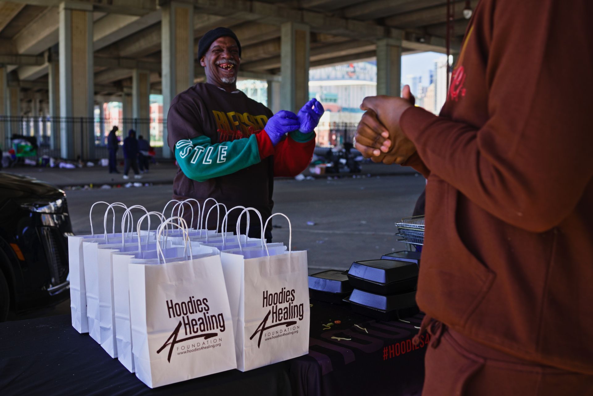 A man is standing in front of a table with a bunch of bags on it.