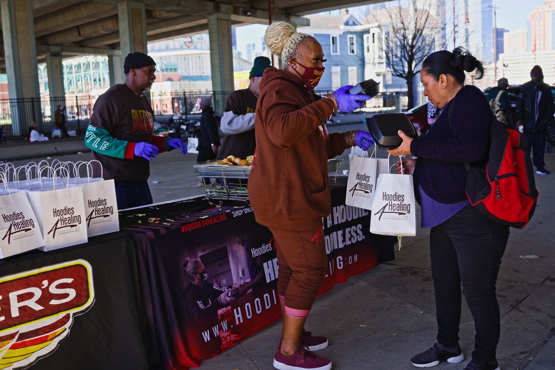 A group of people are standing around a table with a sign that says ' r 's ' on it.