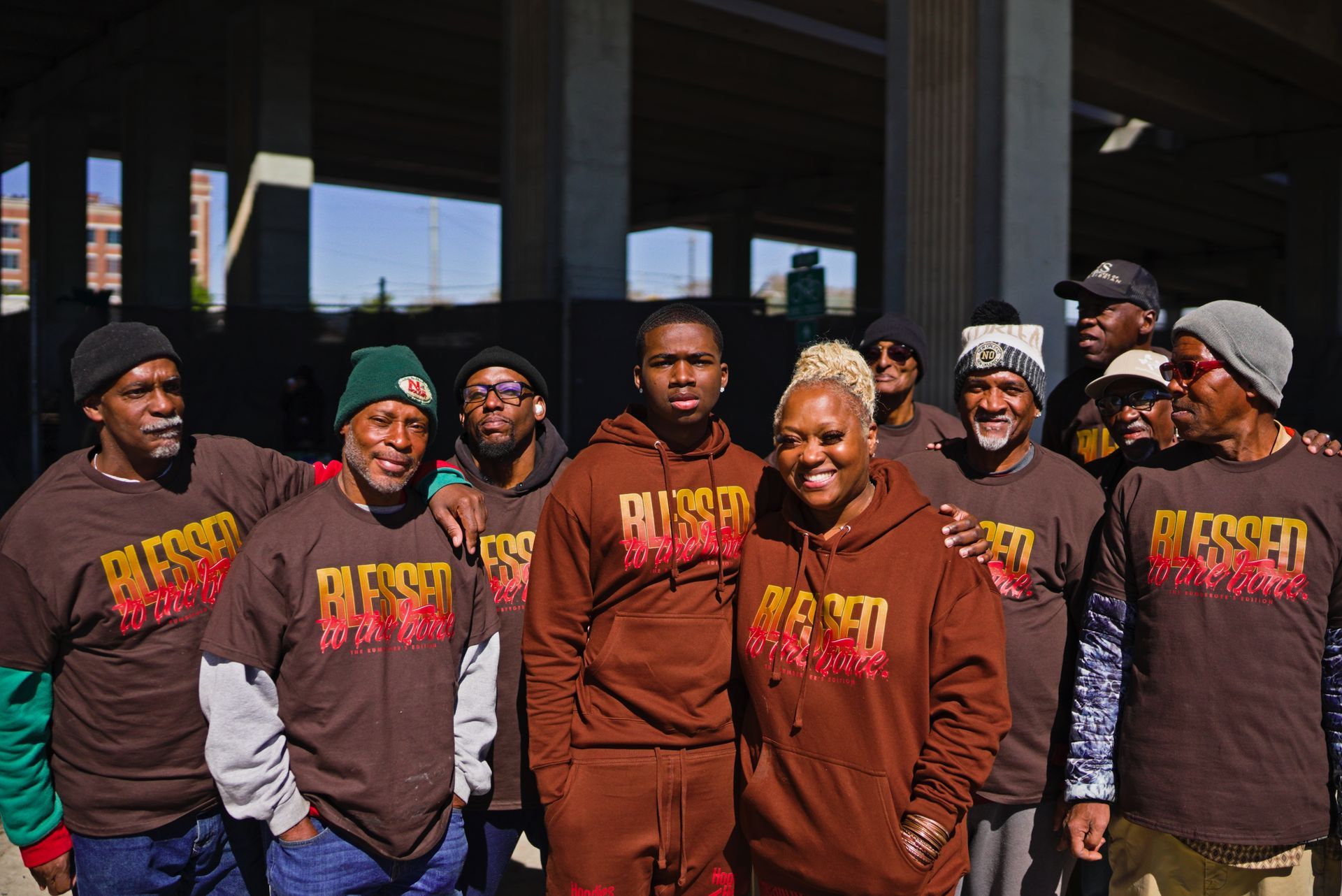 A group of people wearing brown shirts with the word blessed on them are posing for a picture.