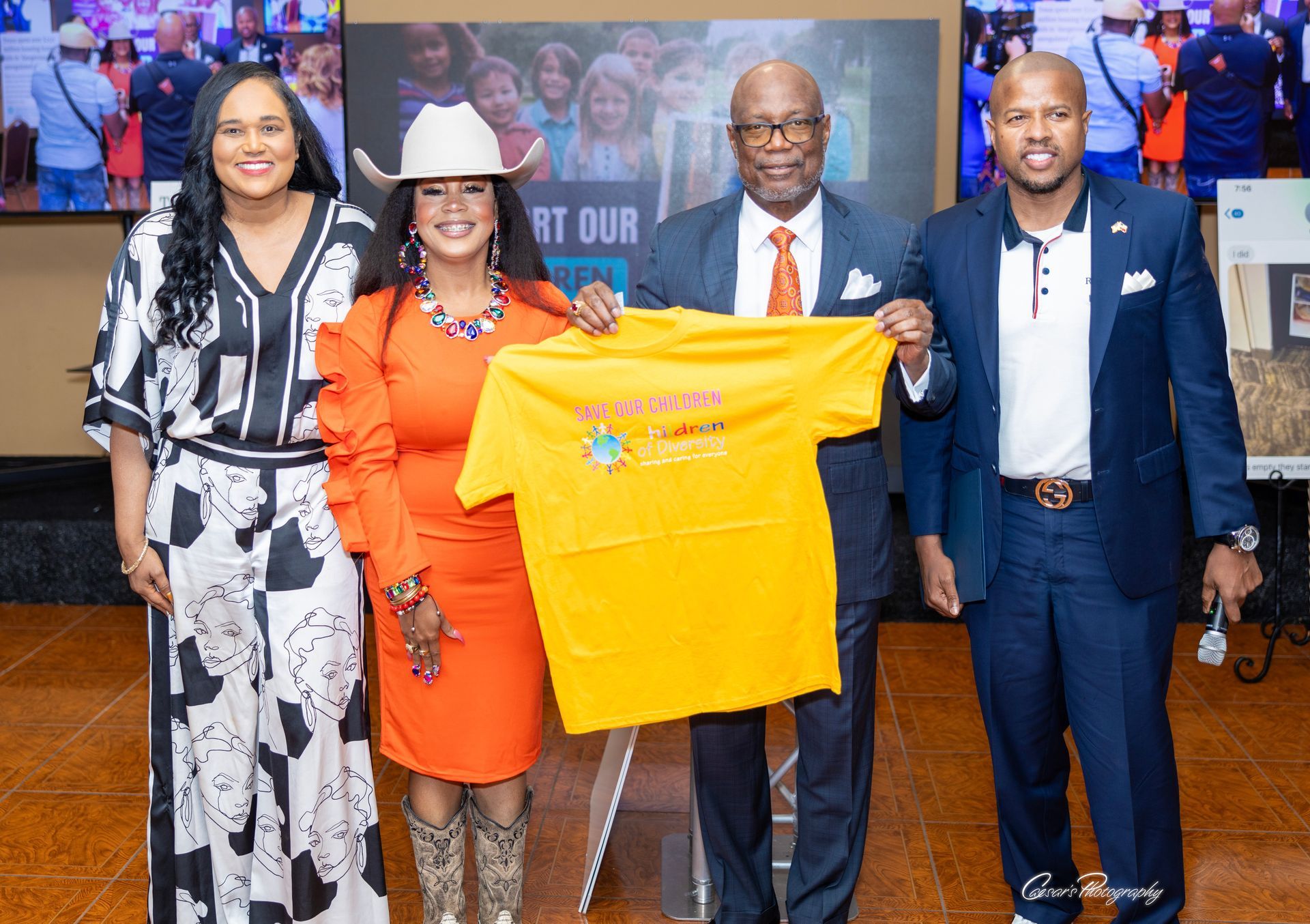 A group of people standing next to each other holding a yellow t-shirt.