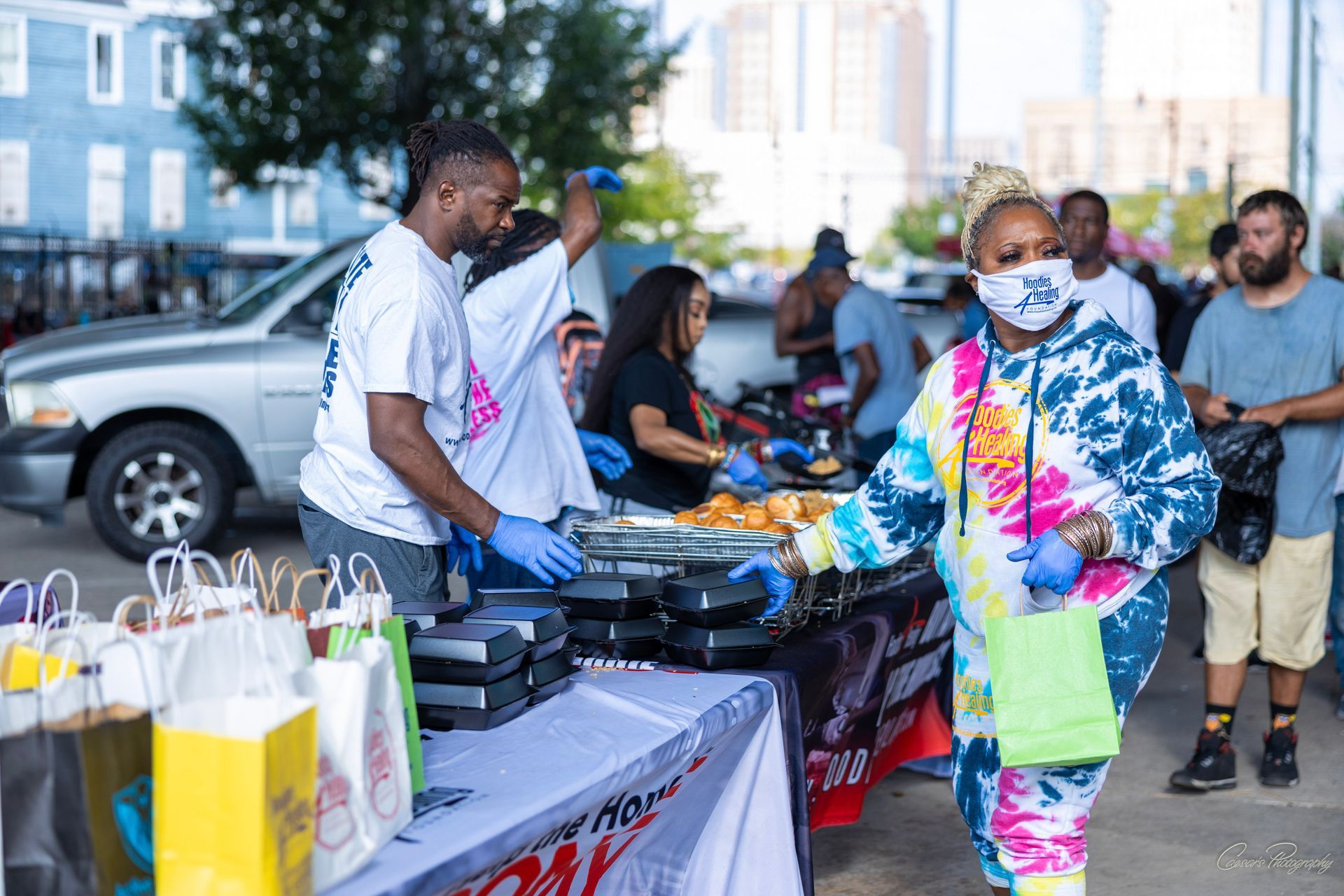 A woman wearing a mask is standing in front of a table with food.