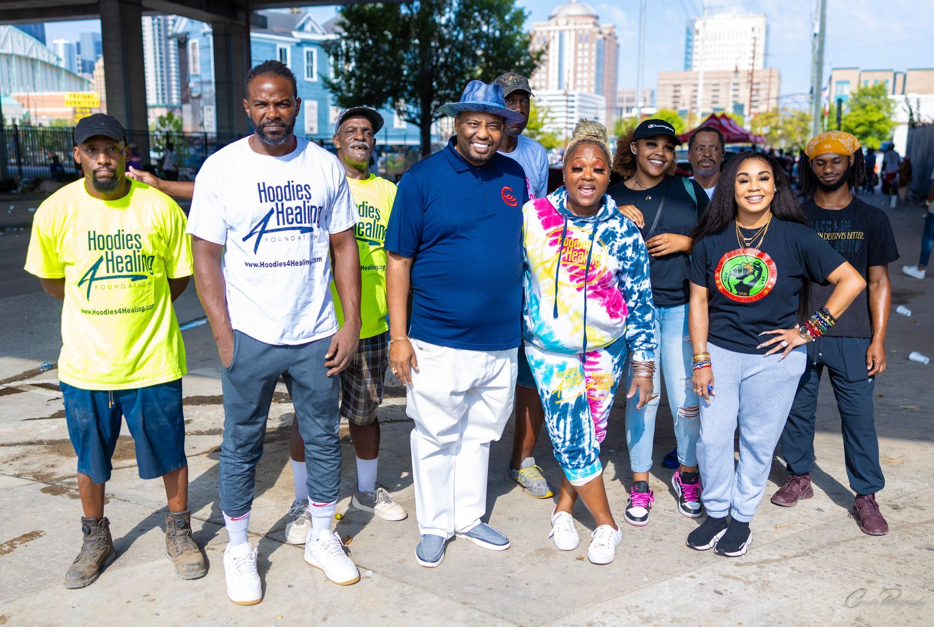 A group of people standing next to each other on a sidewalk.