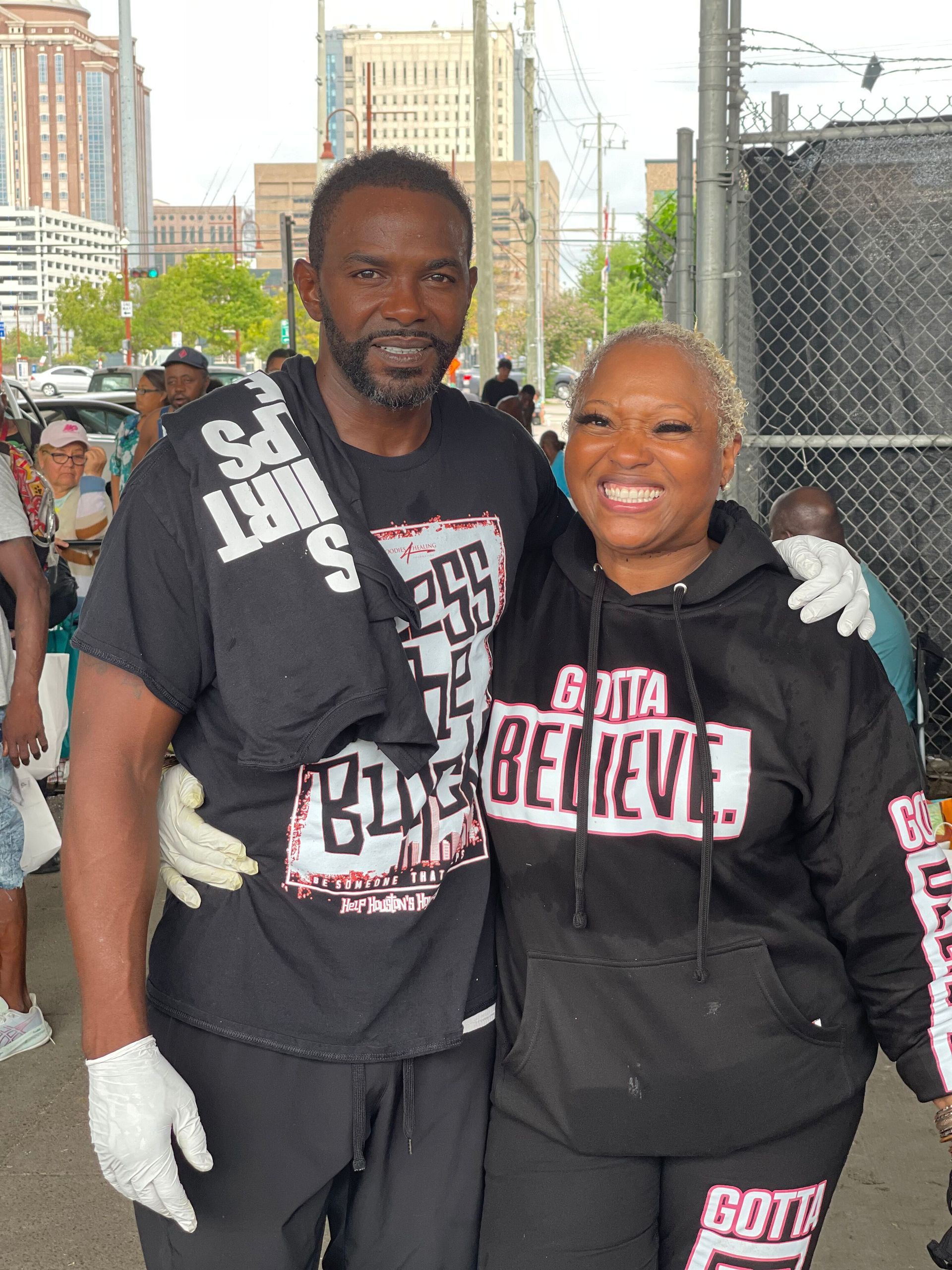 A man and a woman are posing for a picture and the woman is wearing a hoodie that says gotta believe