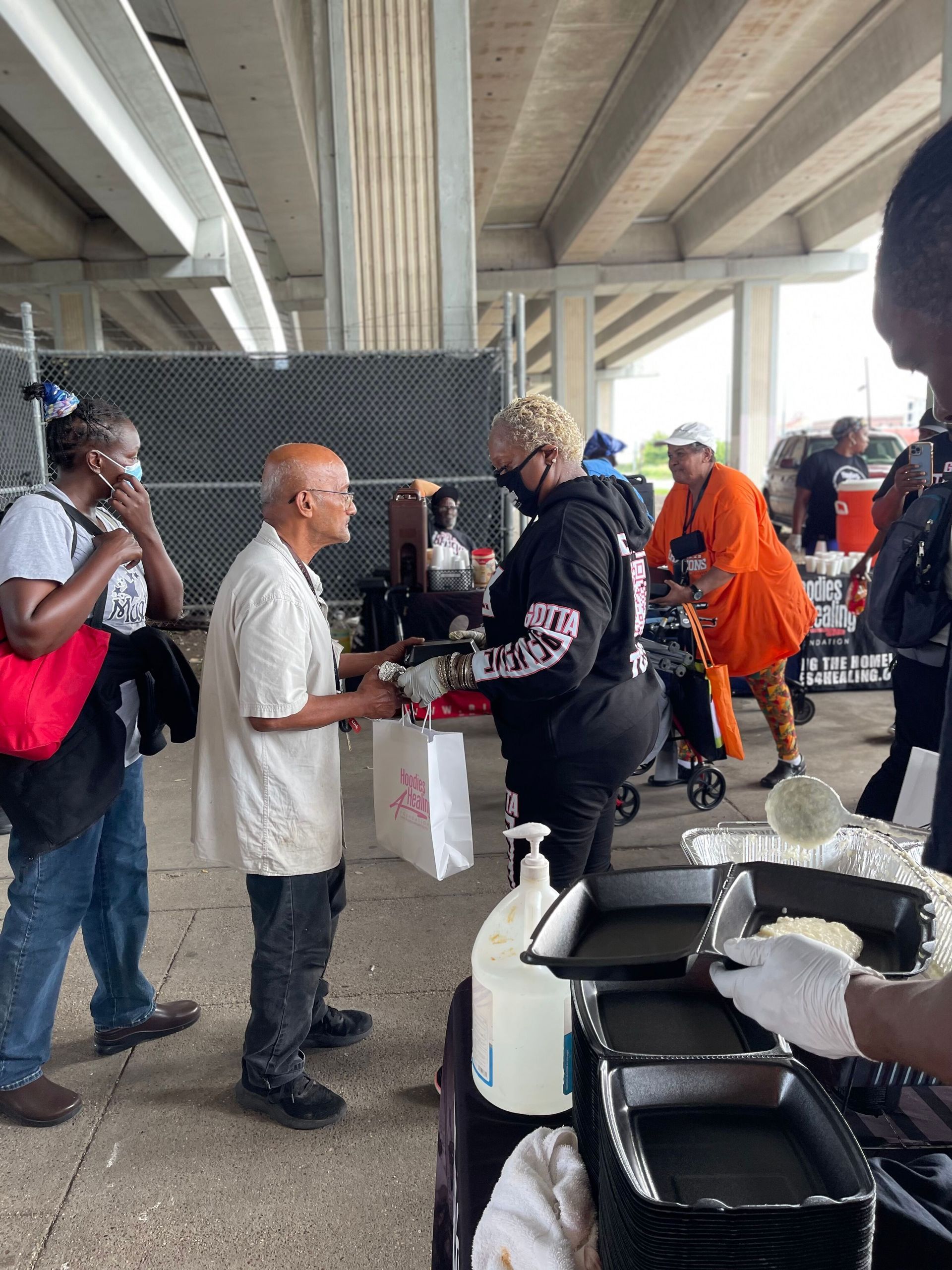 A group of people are standing around a table talking to each other.