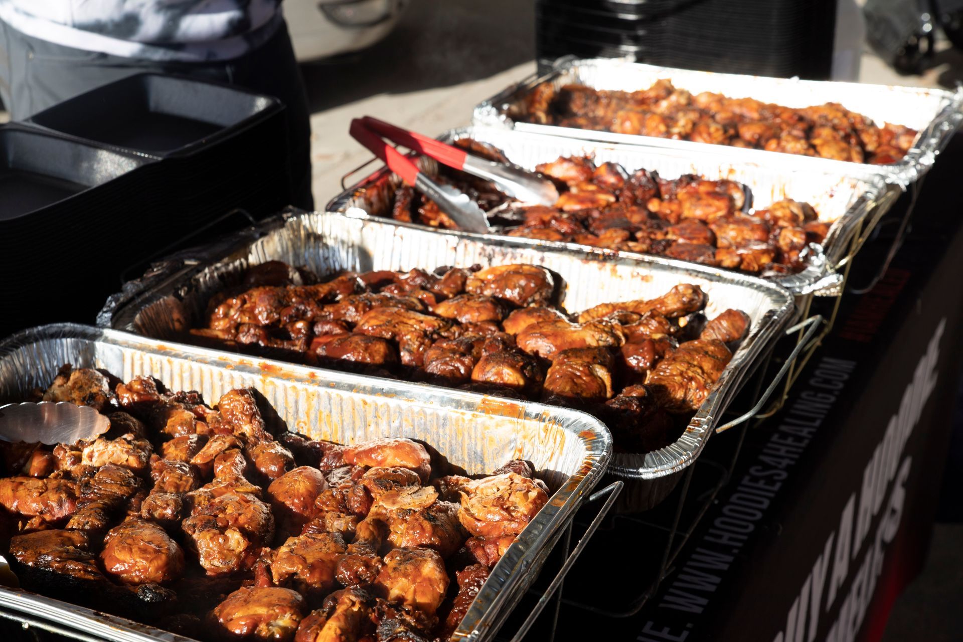 Several trays of food are lined up on a table.