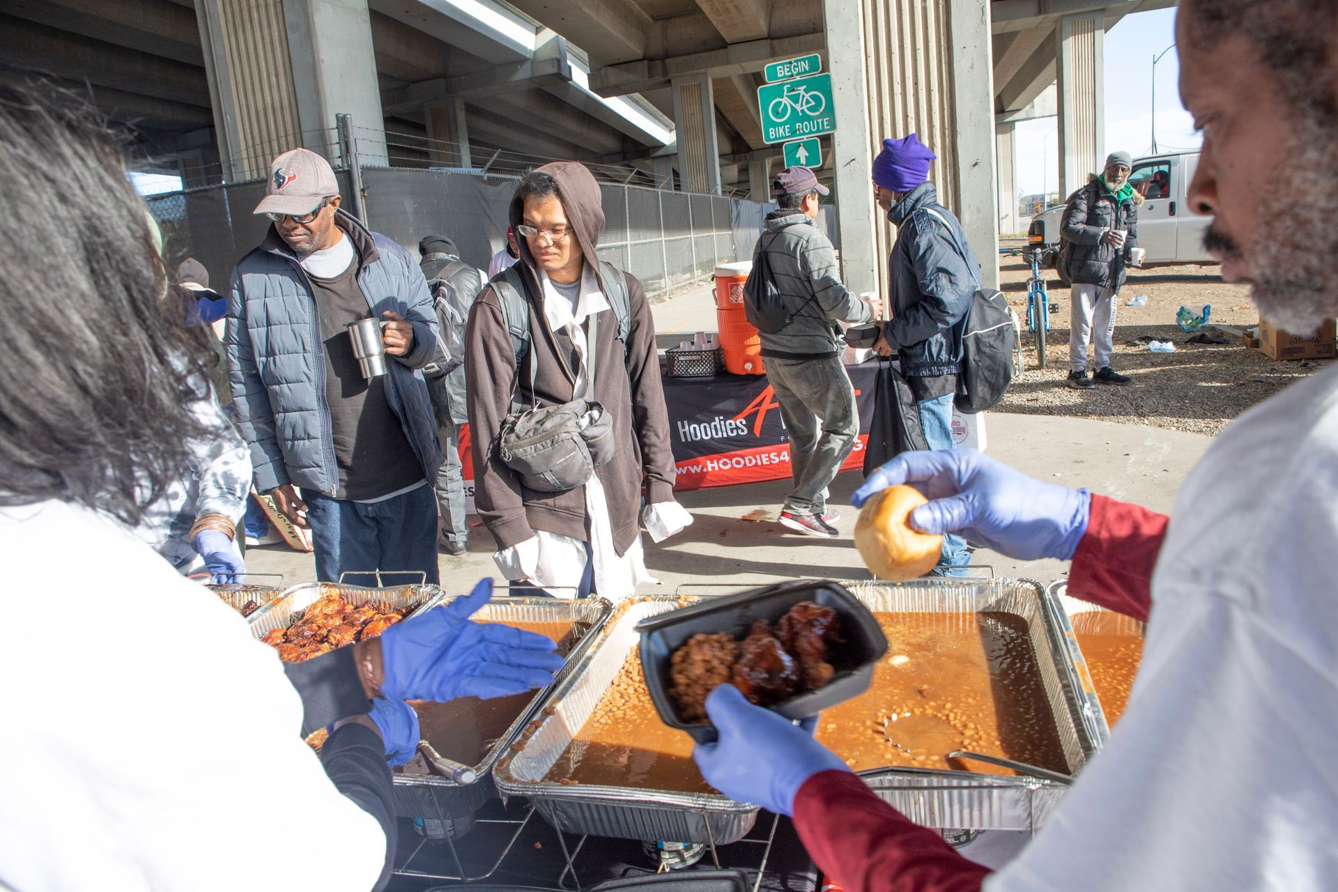 A man is holding a tray of food in front of a group of people.