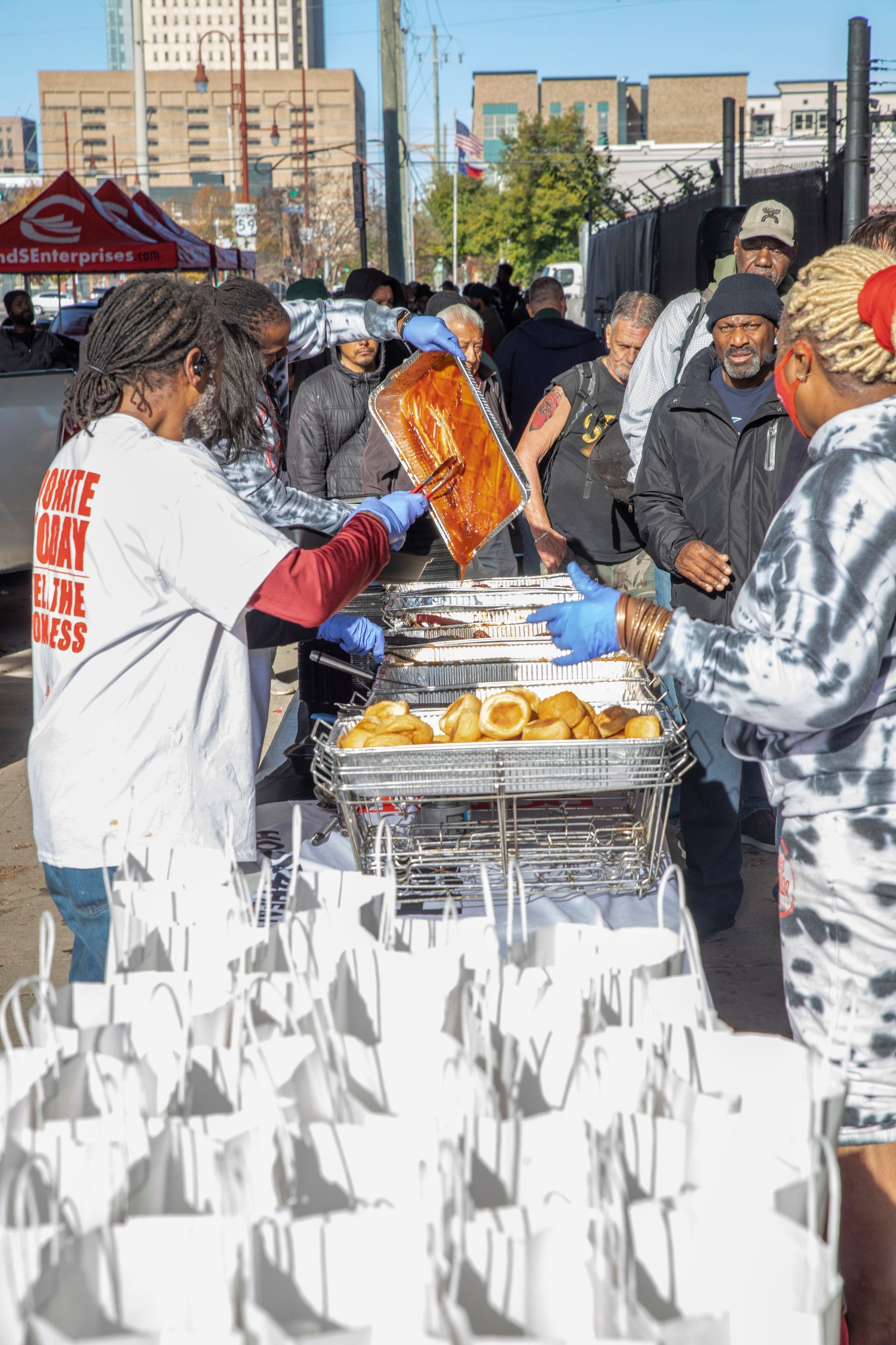 A group of people are standing around a table serving food.